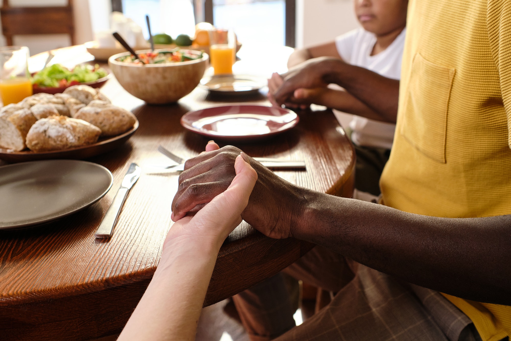 Hands of African man, his Caucasian wife and their son